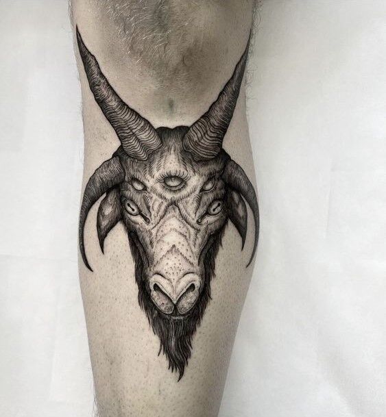 Hình xăm đầu dê phong cách blackwork trên bắp chân, chi tiết sắc nét, độ phân giải HD.