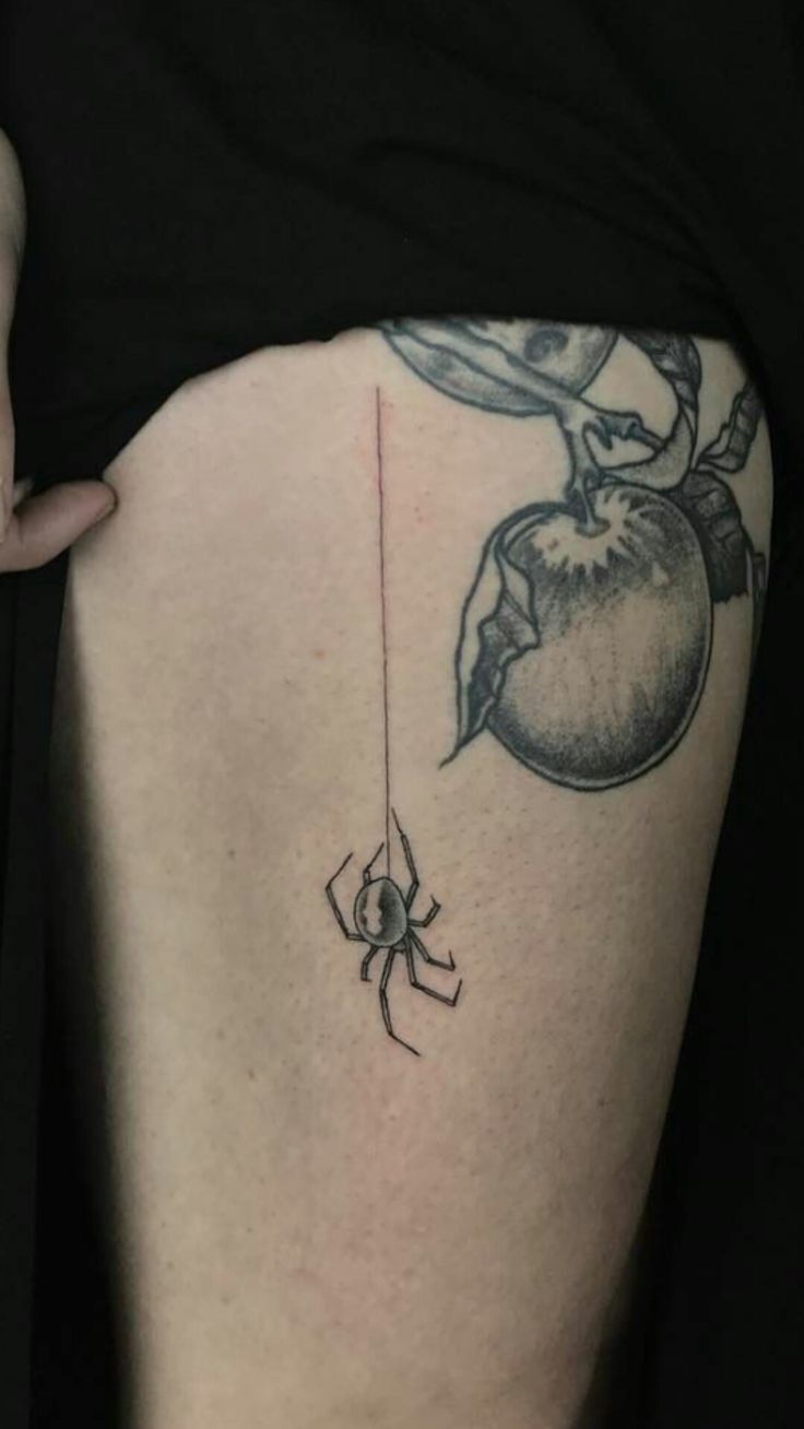 Hình xăm nhện trên đùi, phong cách blackwork, chi tiết tinh tế, độ phân giải HD.