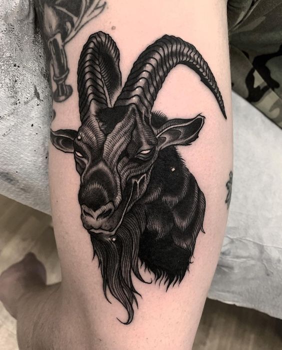 Hình xăm dê phong cách blackwork trên bắp tay, chi tiết sắc nét, độ phân giải HD.