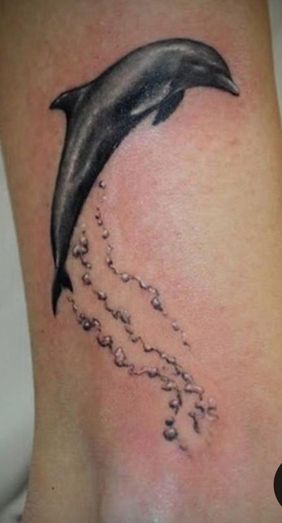 Hình xăm cá heo phong cách blackwork trên cổ chân, chi tiết rõ nét, độ phân giải HD.