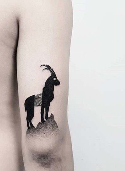 Hình xăm dê phong cách blackwork trên bắp tay, chi tiết rõ nét, ảnh độ phân giải cao.