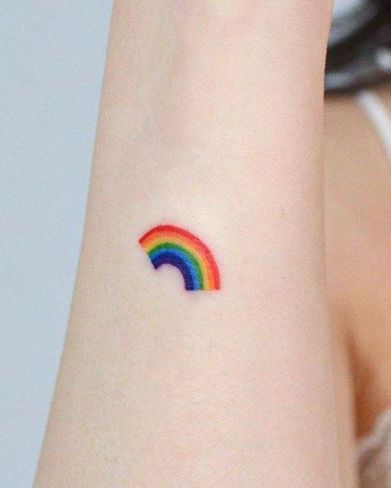 Hình xăm cầu vồng mini trên cánh tay, phong cách màu sắc, chi tiết rõ nét, độ phân giải HD.