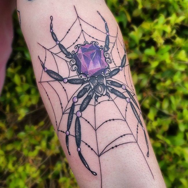 Hình xăm nhện với đá quý trên tay, phong cách blackwork chi tiết. Ảnh chất lượng cao, rõ nét.