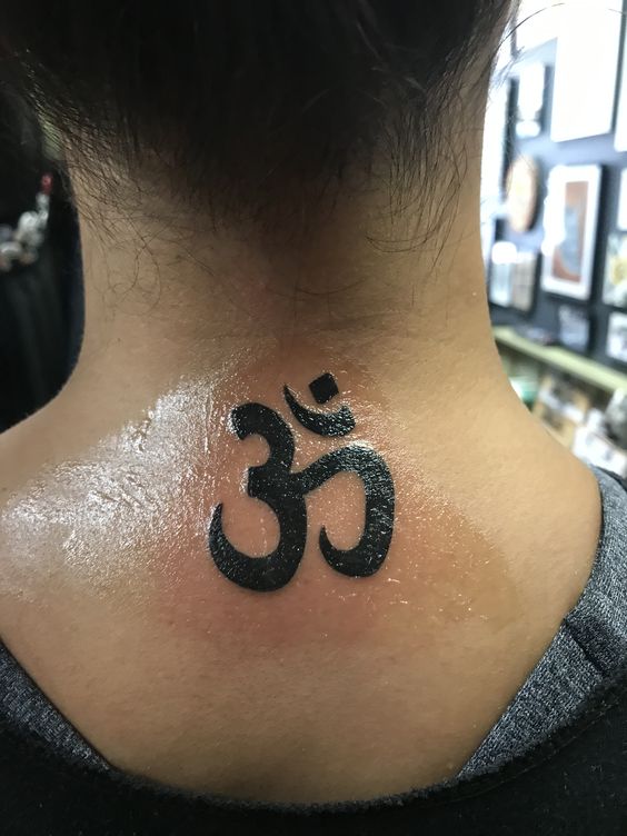 ấn tượng với hình xăm sau gáy cô gái Hình xăm ký tự Om trên gáy, phong cách blackwork, độ chi tiết cao, ảnh HD.