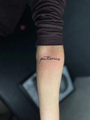 Hình xăm chữ "patience" trên cánh tay, phong cách tối giản, ảnh HD.