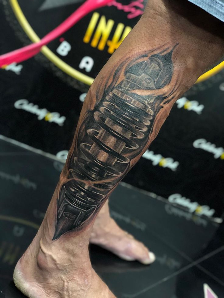 bắp tay anh khách xăm mẫu phuộc ohlins Hình xăm máy móc trên chân, phong cách blackwork chi tiết, độ phân giải HD.