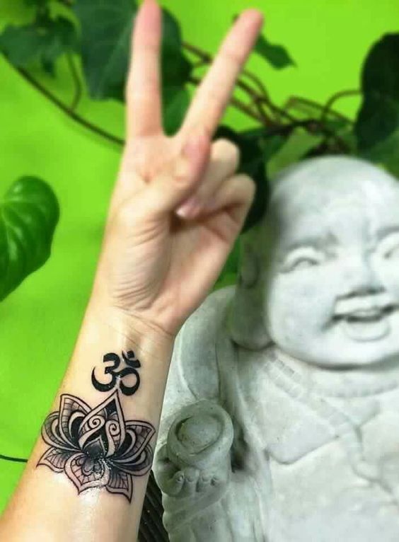 chi tiết xăm chữ om cực đẹp Hình xăm hoa sen và ký tự Om trên cổ tay, phong cách blackwork tinh tế, ảnh độ phân giải cao.