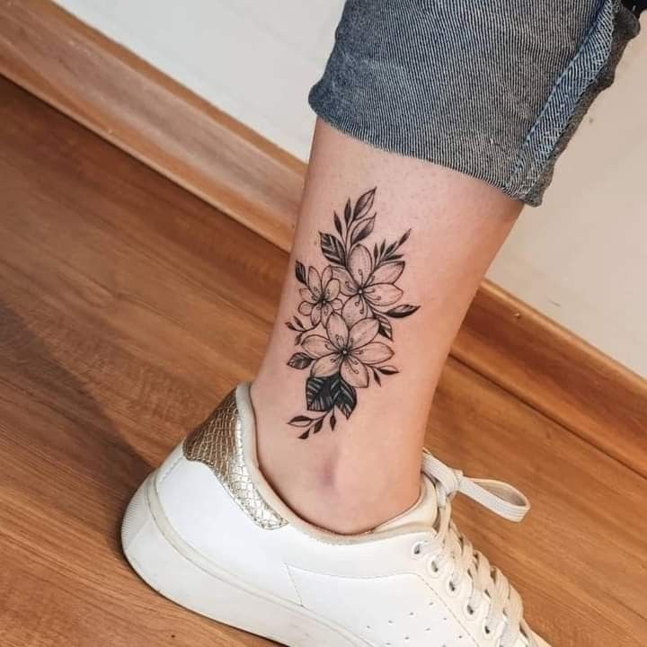 Hình xăm hoa trên mắt cá chân, phong cách blackwork, chi tiết rõ nét, ảnh HD.