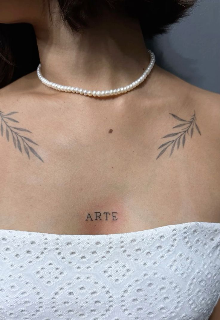 Hình xăm chữ "ARTE" trên ngực, phong cách tối giản, kèm họa tiết lá, ảnh HD.