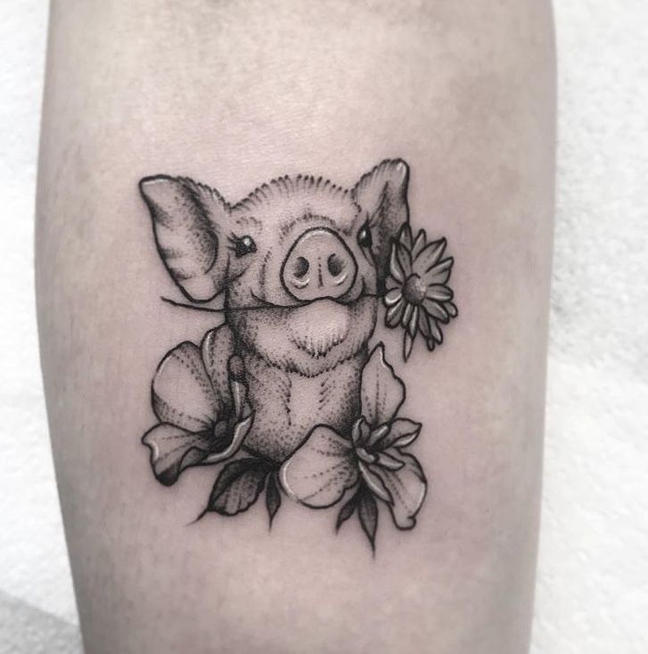 hình tattoo con heo tượng trưng cho sự sung túc Hình xăm lợn và hoa trên bắp tay, phong cách blackwork, chi tiết rõ nét.
