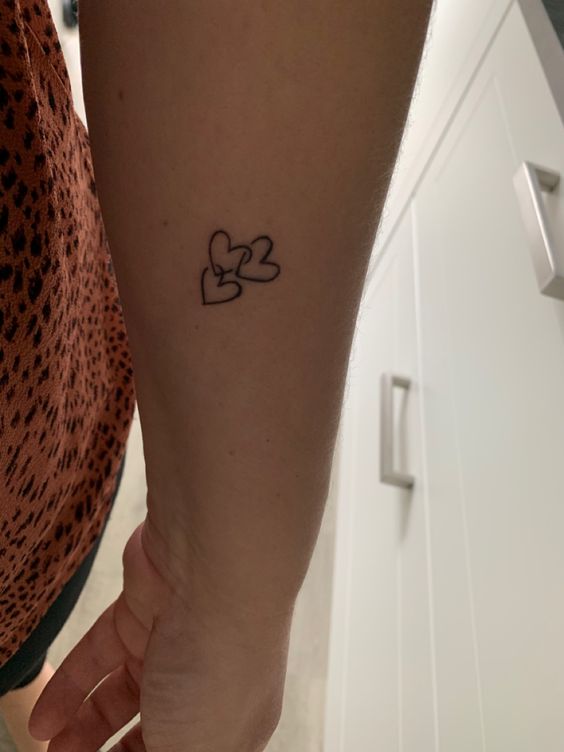 hình xăm ba trái tim vô cùng đáng yêu Hình xăm mini trái tim trên cánh tay, phong cách blackwork đơn giản, ảnh HD rõ nét.