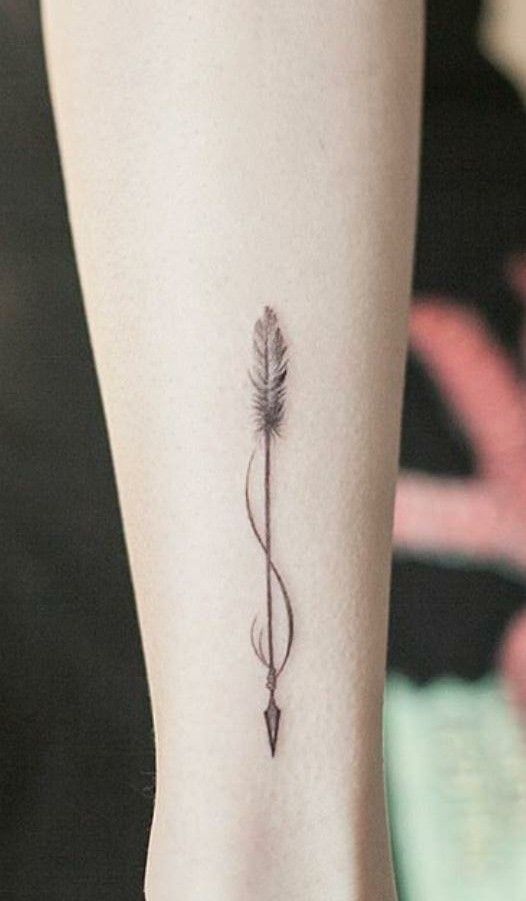 Hình xăm mũi tên mini trên cánh tay, phong cách blackwork, chi tiết đơn giản, độ phân giải HD.