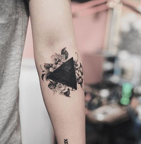 Hình xăm hoa và tam giác trên cánh tay, phong cách blackwork, chi tiết rõ nét, ảnh HD.