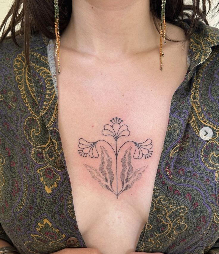 Hình xăm hoa phong cách blackwork trên ngực, thiết kế tối giản, ảnh HD chi tiết.