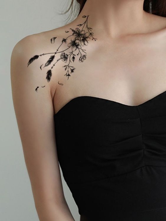 Hình xăm hoa đào thanh nhã trên vai Hình xăm hoa và lông vũ trên vai, phong cách blackwork, chi tiết rõ nét, ảnh HD.