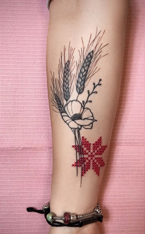 Hình xăm bông lúa đẹp ý nghĩa Hình xăm hoa và bông lúa trên cánh tay, phong cách blackwork kết hợp màu đỏ, chi tiết rõ nét, độ phân giải HD.