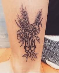 Hình xăm bông lúa kết hợp hoa Hình xăm bông lúa và hoa trên chân, phong cách blackwork, chi tiết rõ nét, độ phân giải HD.