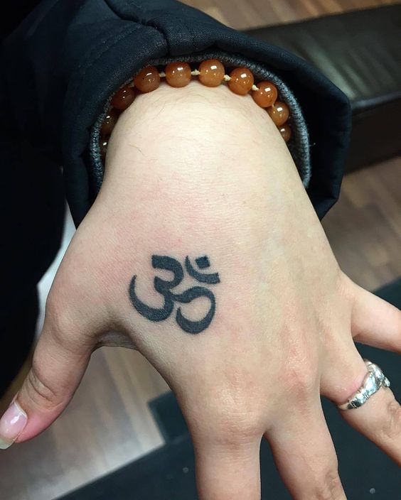 hình xăm các bạn trẻ yêu thích Hình xăm ký hiệu Om trên tay, phong cách blackwork, chi tiết rõ nét, độ phân giải HD.