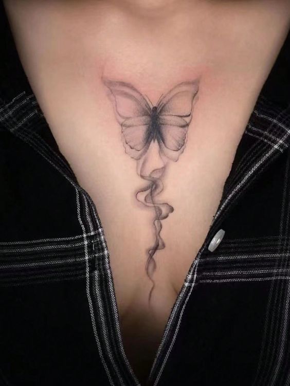 Hình xăm bướm phong cách blackwork ở ngực, chi tiết tinh tế, ảnh độ phân giải cao.