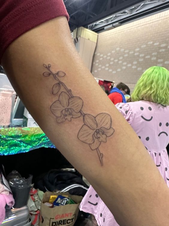 xăm cánh hoa lan trên tay Hình xăm hoa lan trên cánh tay, phong cách blackwork tối giản, độ phân giải HD.