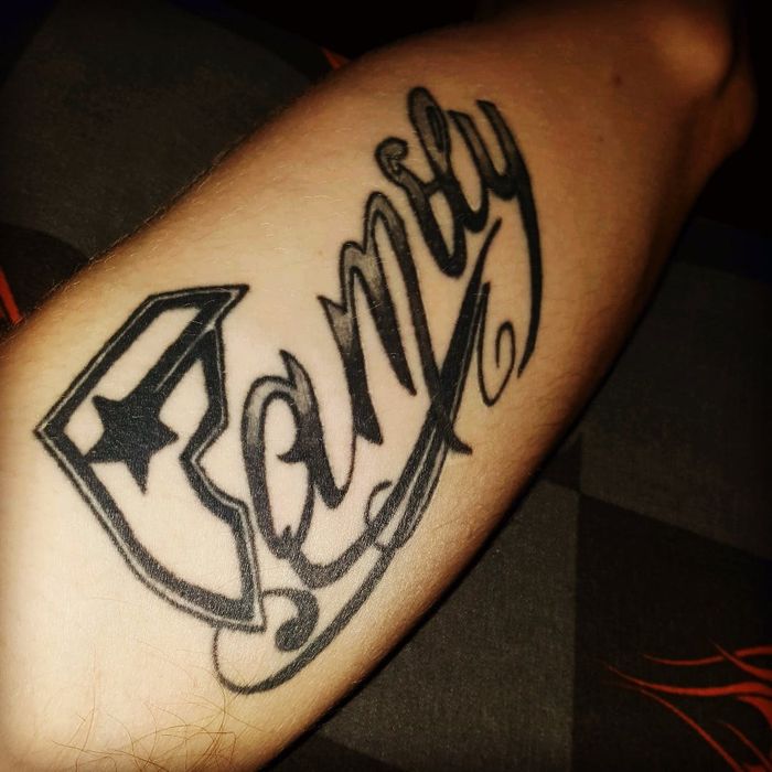 Hình xăm chữ "Family" trên cánh tay, phong cách blackwork, chi tiết rõ nét, độ phân giải hình ảnh HD.