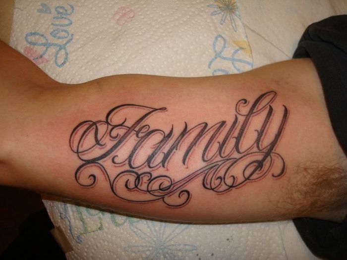 Hình xăm chữ "Family" trên bắp tay, phong cách chữ nghệ thuật, độ chi tiết cao, ảnh HD.