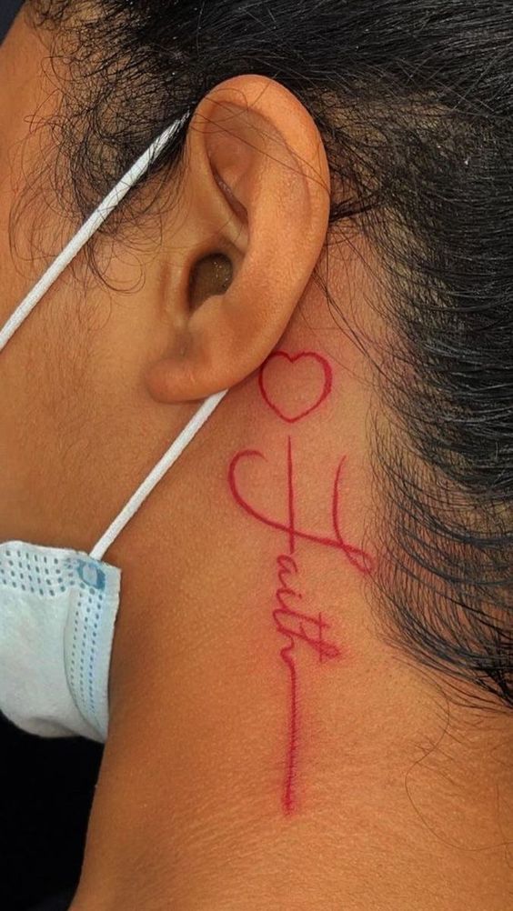 hình xăm chữ mini kèm hình trái tim Hình xăm chữ "Faith" màu đỏ sau tai, phong cách tối giản, chi tiết rõ nét, độ phân giải HD.