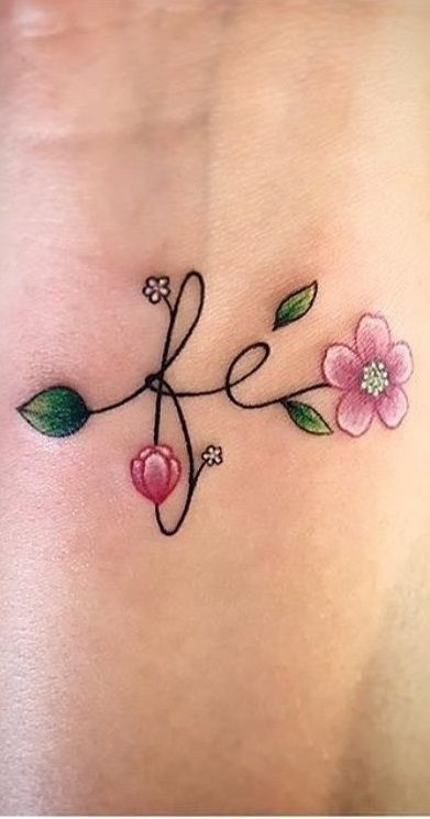 Hình xăm chữ "fé" với hoa màu nước trên da, phong cách tinh tế, vị trí cổ tay, ảnh HD.
