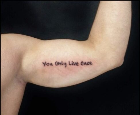 hình xăm chữ you only live once chạy dọc bắp tay Hình xăm chữ "You Only Live Once" trên bắp tay, phong cách tối giản, độ phân giải HD.