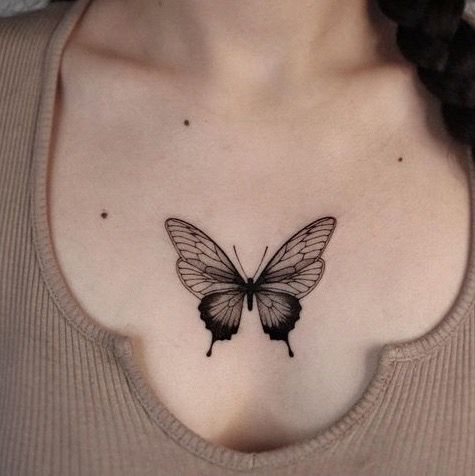 Hình xăm bướm blackwork trên ngực, chi tiết tinh tế, phong cách tối giản, ảnh chất lượng HD.