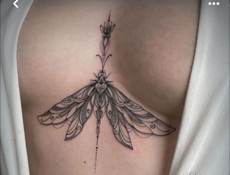 Hình xăm bướm phong cách blackwork chi tiết trên ngực, độ phân giải HD.