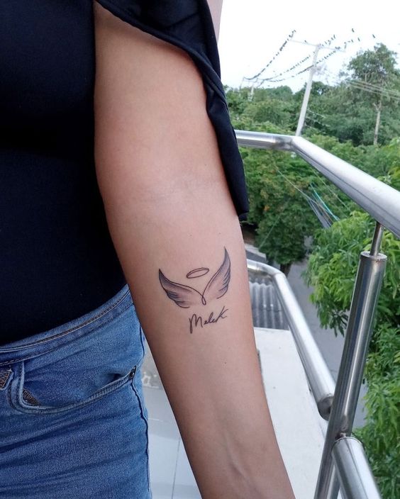 Hình xăm đôi cánh thiên thần trên cánh tay, phong cách blackwork, chi tiết rõ nét, ảnh HD.