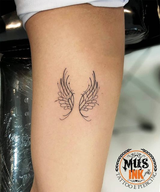 Hình xăm cánh thiên thần mini trên cánh tay, phong cách blackwork, độ chi tiết cao, ảnh HD.