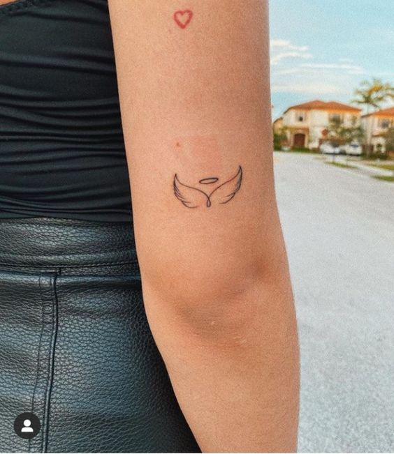 Hình xăm cánh thiên thần mini ở tay, phong cách blackwork, hình ảnh chất lượng cao, chi tiết rõ nét.