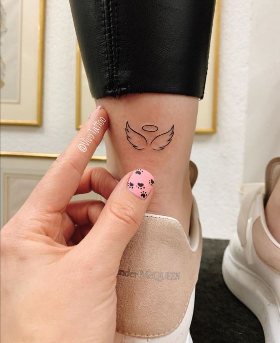 Mini hình xăm đôi cánh thiên thần trên mắt cá chân, phong cách blackwork, ảnh HD rõ nét.