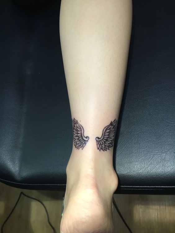 Hình xăm đôi cánh phong cách blackwork, vị trí cổ chân, chi tiết tinh tế, độ phân giải HD.