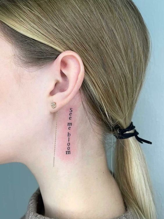Hình xăm chữ mini sau tai, phong cách blackwork, chi tiết rõ nét, độ phân giải HD.