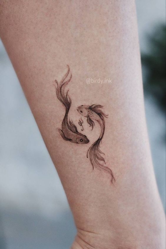 Hình xăm cá mini trên cánh tay, phong cách blackwork, chi tiết tinh tế, ảnh chất lượng HD.