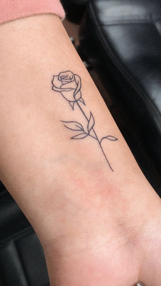 Hình xăm hoa hồng tối giản trên cổ tay, phong cách blackwork, chi tiết rõ nét, ảnh chất lượng HD.