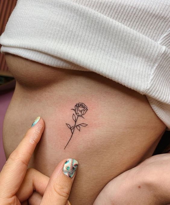 Hình xăm hoa hồng mini phong cách blackwork trên hông, chi tiết rõ nét, ảnh HD.