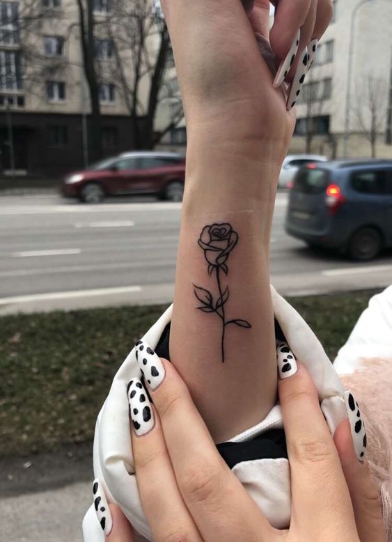 Hình xăm hoa hồng mini trên cổ tay, phong cách blackwork, ảnh độ phân giải cao.