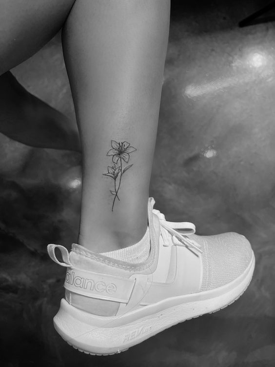 Hình xăm hoa mini trên chân, phong cách blackwork, chi tiết rõ nét, ảnh độ phân giải HD.