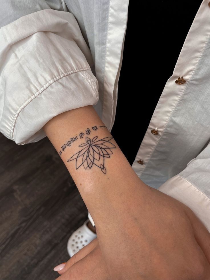 Hình xăm hoa mini phong cách blackwork trên cổ tay, chi tiết rõ nét, độ phân giải HD.