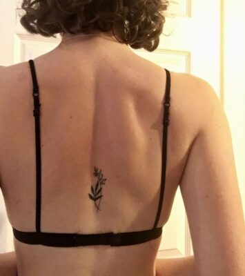 Hình xăm hoa mini trên lưng, phong cách blackwork, ảnh độ phân giải cao.