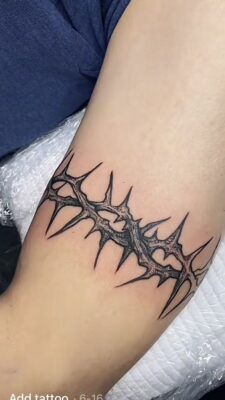 Hình xăm vòng gai trên bắp tay, phong cách blackwork, chi tiết sắc nét, ảnh HD.
