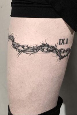Hình xăm chuỗi gai trên đùi, phong cách blackwork, chi tiết rõ nét, độ phân giải HD.