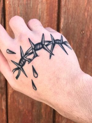 Hình xăm dây thép gai trên mu bàn tay, phong cách blackwork, chi tiết, ảnh HD.
