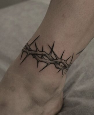 Hình xăm vòng gai ở cổ chân, phong cách blackwork, chi tiết sắc nét, ảnh HD.