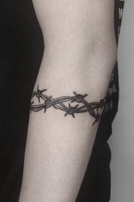 Hình xăm vòng kẽm gai trên tay, phong cách blackwork, chi tiết sắc nét, độ phân giải HD.