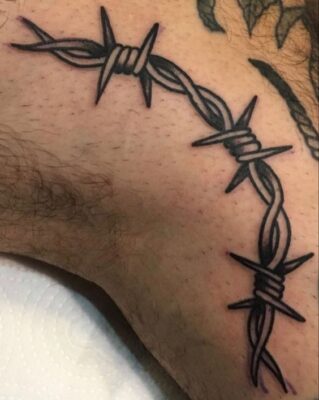Hình xăm dây thép gai trên cánh tay, phong cách blackwork, chi tiết rõ nét, độ phân giải HD.